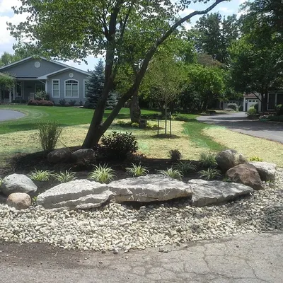 This is what a project looks like right after I finish. I've built a new landscape bed using large boulders for a natural border, added some new plants, and put down fresh grass seed. Soon, it will all grow in and look beautiful.