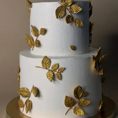 This two-tiered cake with delicate, hand-painted golden leaves is a testament to simple elegance. It was a humbling experience working with fondant to create this clean, minimalist design for a very special couple.