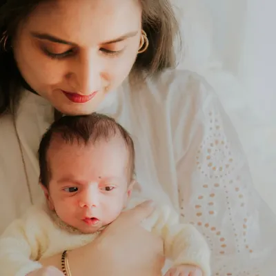 A mother looks down at her newborn with pure adoration. This in-home session captures the quiet, beautiful reality of the first few days with a new baby.