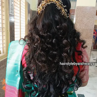 Gorgeous, voluminous curls for a naming ceremony. This half-up hairstyle is decorated with a delicate hair accessory, letting the long, bouncy curls flow freely.