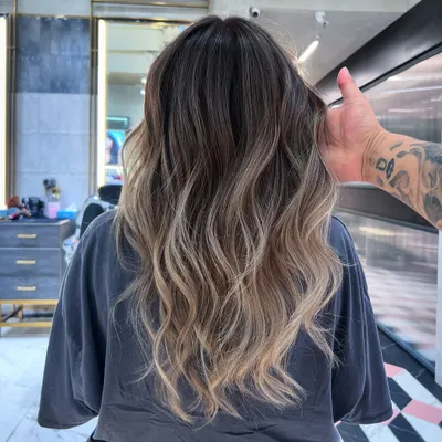 This is a beautiful example of an ash-blonde balayage. I used Redken 09T and 09B to create this cool, smoky transition from a natural dark root to light, wavy ends.