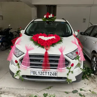 A popular design for a wedding car featuring a heart made of red roses on the bonnet. The look is completed with red and pink ribbons, making the car look festive and ready for the baraat.