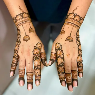 A chic and modern design featuring lotus outlines trailing down the fingers, with delicate jhumka (bell) motifs.