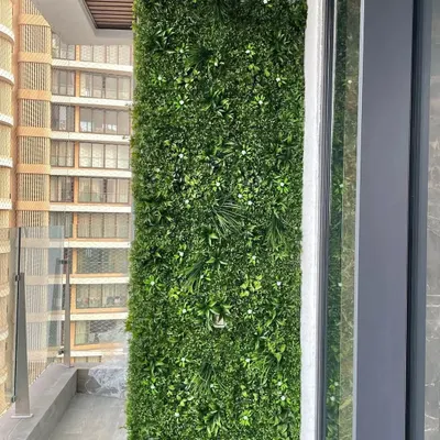 This full-height artificial green wall completely revitalizes a high-rise apartment balcony. The dense, realistic foliage adds a touch of nature and privacy, creating a personal sanctuary in the middle of the city.