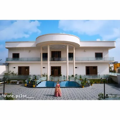 This grand bridal portrait was taken with a drone to capture both the bride in her beautiful lehenga and the impressive architecture of the venue, making her look like royalty.