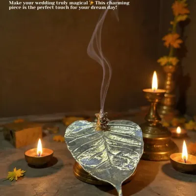 Add a touch of magic to your wedding rituals with this charming peepal leaf incense holder. The smoke gracefully rises from the leaf, creating a serene and divine atmosphere for your pooja.