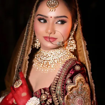 This is the quintessential bridal look I love to create. It features sharp, winged eyeliner, a bold lip, and a perfectly sculpted base that complements the heavy velvet lehenga and polki jewelry, making for a truly royal bride.