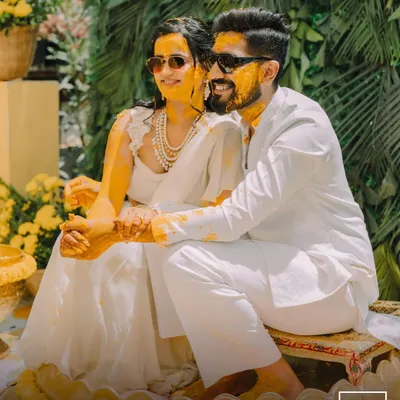 The perfect Haldi portrait, with the couple looking cool and happy in their sunglasses, covered in turmeric. This shot captures the fun and modern vibe of their celebration.