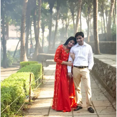 A classic, romantic pose from a pre-wedding shoot in a park. The couple's gentle embrace and the lush green surroundings create a timeless and serene portrait.