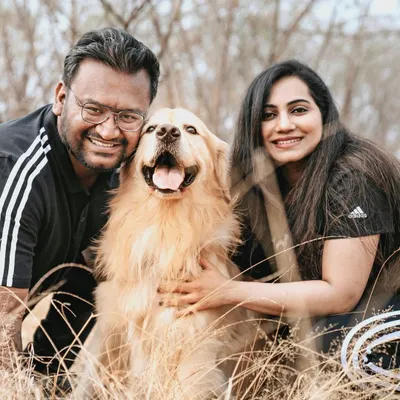 A beautiful family portrait in a field of golden grass. The genuine smiles on everyone's faces, including Archie the golden retriever, say it all.