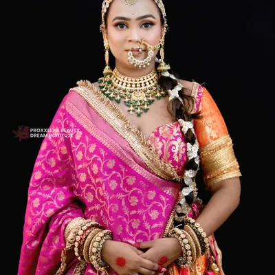 A queen stepping into her era of love. This look features a vibrant pink and orange lehenga, complemented by makeup that is both bold and graceful, with a focus on glowing skin.