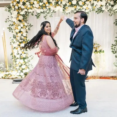 The first dance as husband and wife. The bride's twirling lehenga and the couple's happy faces make this a perfect reception shot.