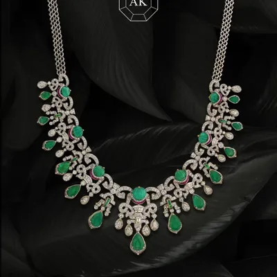 Where tradition meets bold design. This striking necklace blends two shades of natural Zambian emeralds with round and baguette diamonds, accented with a hint of ruby. It's handcrafted with a modern touch, perfect for carrying culture with style.