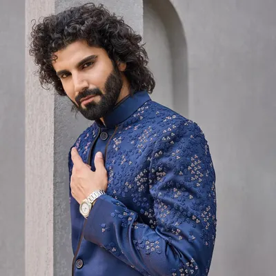 A close-up of this navy blue bandhgala reveals the subtle, geometric hand-embroidery. It's a perfect example of understated luxury, designed for the discerning gentleman.