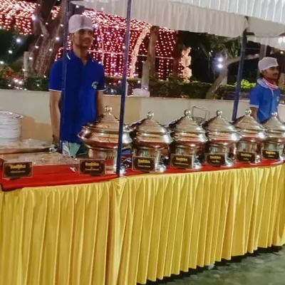 A full view of our buffet station at an evening wedding reception. We arrange everything neatly, from the plates to the series of food warmers, ensuring a smooth and organized service for your guests.