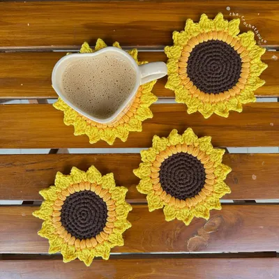 A cozy lifestyle shot of our handmade crochet sunflower coasters. These are perfect for adding a pop of color to your home decor or including in a gift hamper.