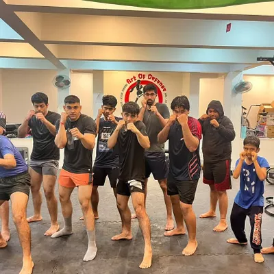 Hands up, chin down. A group of our members, a mix of teens and adults, hold their fighting stance for a team photo after a demanding training session.