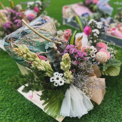 This luxurious hamper combines traditional elegance with natural textures. A printed saree is styled in a jute basket with an abundance of fresh, wild-looking florals, creating a gift that feels both opulent and organic.