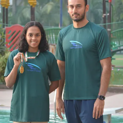 Head Coach Virdhawal Khade stands with national gold medalist Nirmayee Ambetkar. Direct mentorship from an Olympian is a key part of our program's success.