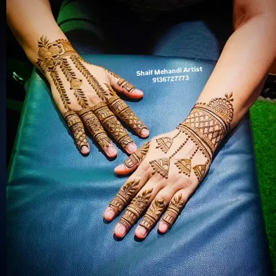 A chic and modern back-of-hand design. One hand features hanging jhumka (bell) motifs, while the other has a leafy vine pattern, showing how you can mix and match minimalist styles.