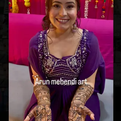 A happy bride proudly displaying her custom portrait mehendi. Her smile says it all!