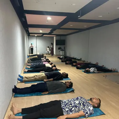 Employees of a company resting during a corporate wellness session. Providing a space for teams to lie down and receive a sound bath is an effective way to combat collective stress and burnout.