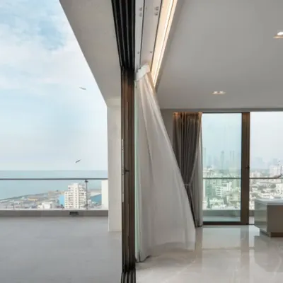For this Mumbai penthouse, the design is intentionally minimal to let the stunning sea view take center stage. The open, clutter-free space and the gentle breeze animating the curtains create a tranquil retreat high above the city.