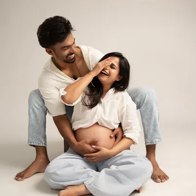 A playful and intimate moment. This candid shot captures genuine laughter and connection, showcasing a modern and relaxed approach to maternity photography.