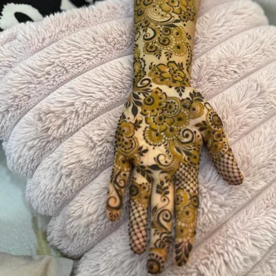 An intricate floral design on the back of the hand, with delicate vines and checkerboard patterns on the fingers.
