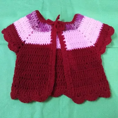 This adorable baby cardigan is a perfect project for beginners. You'll learn how to create the main body, shape the sleeves, and add a delicate scalloped edge, all using basic crochet stitches.