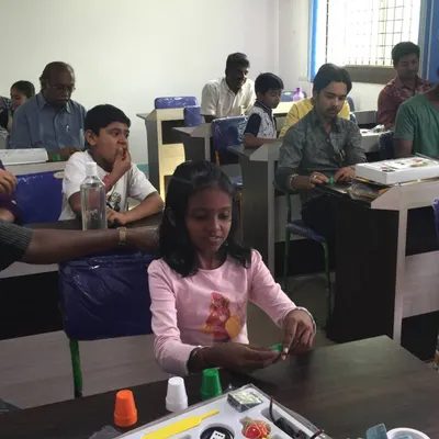 Here you can see the fun in action. Students, both young and old, are getting hands-on with their personal magic kits, practicing the cups and balls trick. This is what my workshops are all about: interactive learning for everyone.