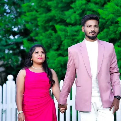 One step closer to forever. This couple looks lovely in their coordinated outfits for a pre-wedding shoot. She is in a flowing pink gown, and he is in a matching pink blazer with white trousers.