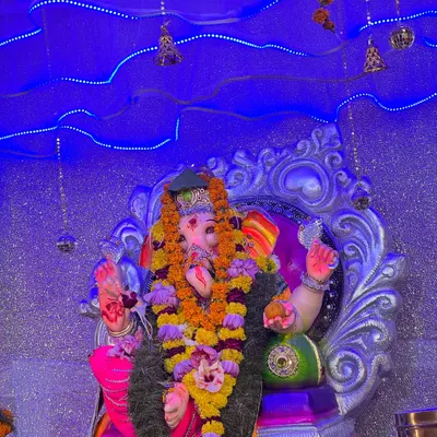 A close-up of a Ganpati idol, with my custom lighting setup in the background. I use blue LED lights and hanging bells to create a divine and serene atmosphere for the puja.