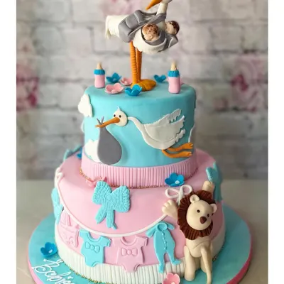 A spectacular two-tier cake for a twin baby shower! The design features a stork delivering two babies, with adorable pink and blue details. We love creating these elaborate, story-telling cakes.