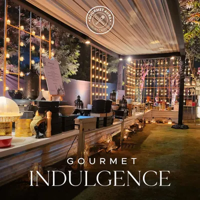 A stunning outdoor buffet setup at night, with warm lighting creating an inviting and magical atmosphere. This is gourmet indulgence on a grand scale.