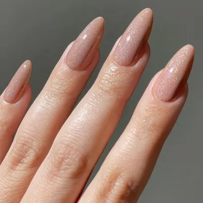 A beautiful and elegant set of long stiletto nails in a shimmering nude gel polish. This color has a subtle glitter that catches the light perfectly.