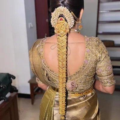 A full view of a traditional bridal braid adorned with a complete gold temple jewellery set, known as 'Jadai Alangaram'. The craftsmanship ensures the hair looks regal from every angle.
