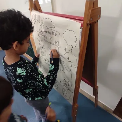 Our K1 and K2 students bring grammar to life by drawing and identifying nouns. This collaborative drawing on an easel shows how we make abstract concepts like 'person, place, or thing' tangible and fun.
