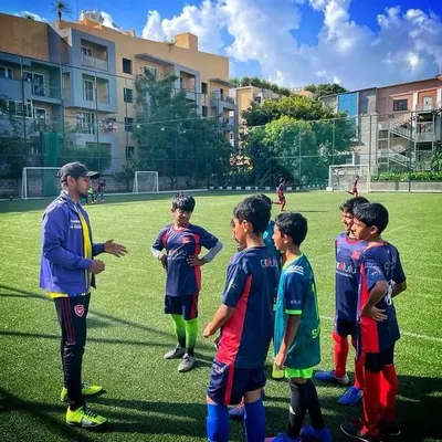 A coach discussing strategy with his team on the turf. We believe in empowering our players with the knowledge to make smart decisions during a match.