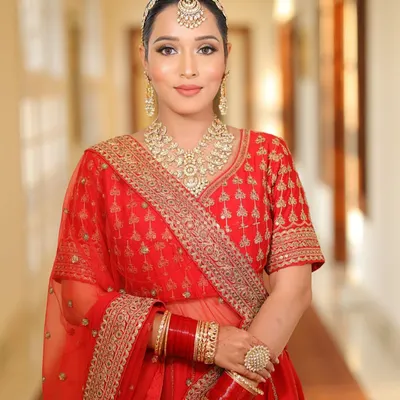 A full portrait of a stunning bride in her red lehenga. My goal was to create a balanced look with classic red lips and defined eyes that complement the heavy embroidery and jewelry.