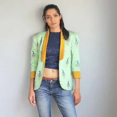 This look perfectly captures my love for fusion wear. I designed this structured blazer with traditional peacock embroidery and paired it with a modern sequin crop top and jeans. It’s a powerful, stylish look for any woman.
