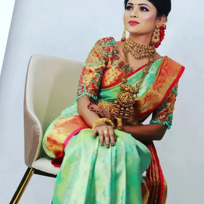 A stunning shot from a jewellery marketing campaign. The model is wearing a beautiful Kanchipuram half-saree, and the makeup is designed to be bold and glamorous to complement the intricate jewellery.