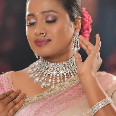 A beautiful close-up of a soft glam look on a dusky-skinned bride. The pink and silver tones of the makeup and jewelry create a stunning, ethereal glow.