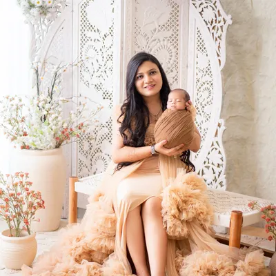 A serene portrait of a new mother holding her swaddled newborn. I use soft, neutral-toned wraps to keep the focus on the baby's delicate features.