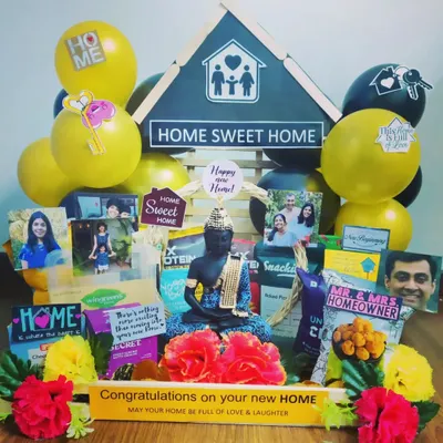 Celebrate a new home with this thoughtful housewarming hamper. It features a decorative 'Home Sweet Home' centerpiece, a Buddha statue for peace, and is filled with snacks and personalized photos.