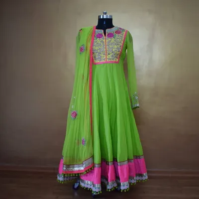 This full-length view shows the beautiful flare of the neon green Anarkali. The combination of the bright color, floral embroidery, and gota patti border makes it a truly standout piece for any festive occasion.