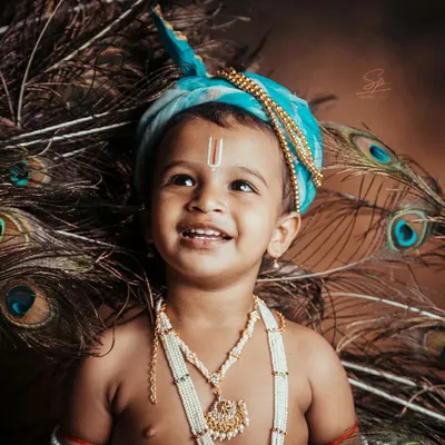 The innocent, upward glance of our little Krishna, framed by peacock feathers. This portrait highlights the detailed styling, from the turban to the pearl necklaces, that makes my themed shoots so special.