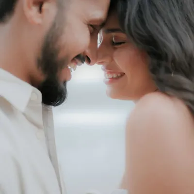 A close-up of a couple's happy, smiling faces as they touch foreheads. This candid portrait captures a moment of pure joy and affection, a signature of our couple photography style.