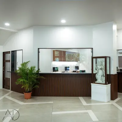 The main reception desk at Maniben Nanavati Women's College. I used dark, fluted wood panels to add texture and warmth, contrasting with the clean white walls and bright, modern lighting to create a professional first impression.