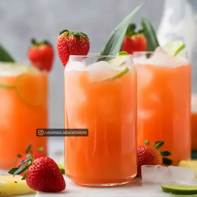 A refreshing Strawberry Pineapple Punch served over ice with a lime garnish. This is one of our many colorful and delicious welcome drinks perfect for summer events.